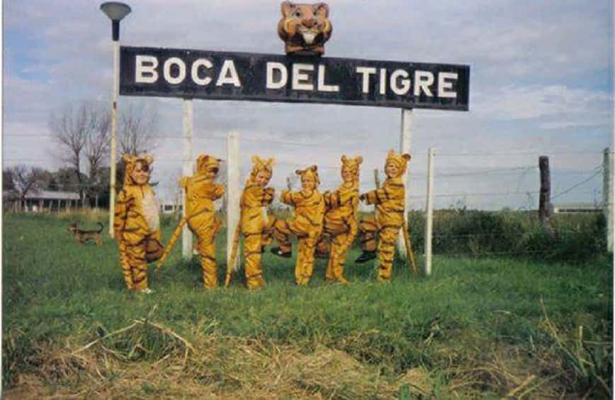 Dos jóvenes trabajan para la restauración de la cabeza de tigre, ícono del cartel de entrada a Boca del Tigre